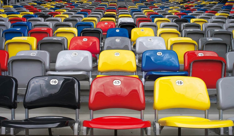 Colourful seats in MERKUR SPIEL-ARENA. The seats are shown in the colours black, red, blue, yellow and grey.